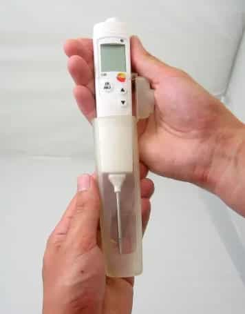 Dwie dłonie trzymające miernik testo 106 z założoną przezroczystą osłoną ochronną TopSafe (miniatura)