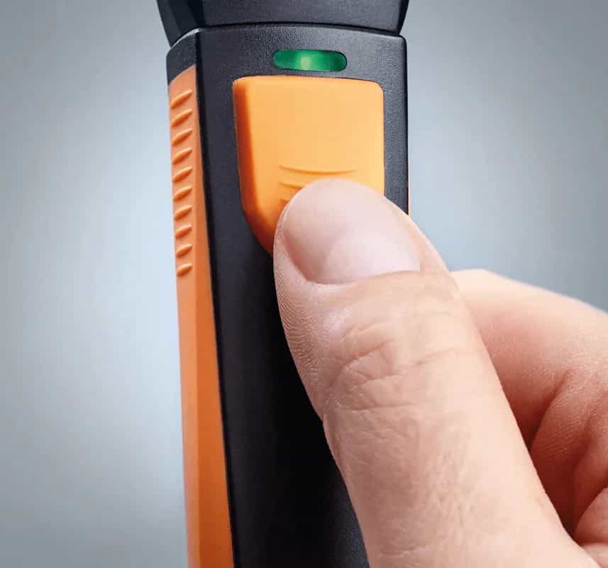 Zbliżenie na kciuk naciskający pomarańczowy przycisk manometru różnicowego Testo 510i (miniatura)