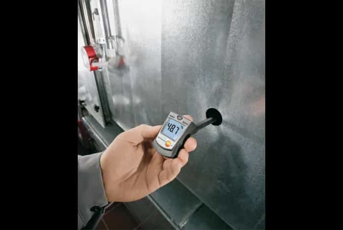 Testo 605-H1 w dłoni technika podczas pomiaru wilgotności w kanale wentylacyjnym (miniatura)
