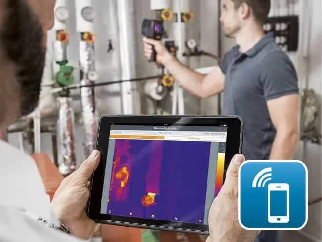 Serwisant w kotłowni steruje kamerą Testo 868s z poziomu tabletu z aplikacją testo Thermography App (miniatura)