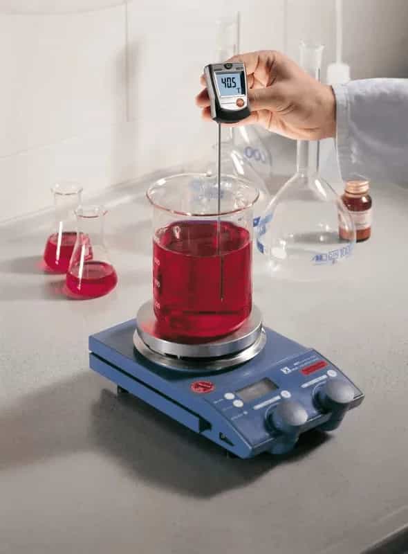 Testo 905-T1 mierzący temperaturę czerwonego płynu w kolbie na mieszadle magnetycznym w laboratorium (miniatura)