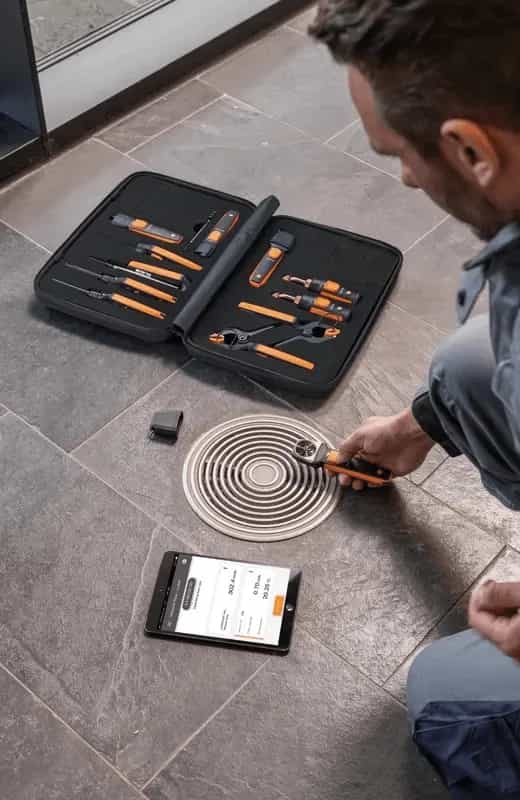Technik siedzący na posadzce konfiguruje zestaw Testo SmartSond z tabletem wyświetlającym Testo Smart App (miniatura)