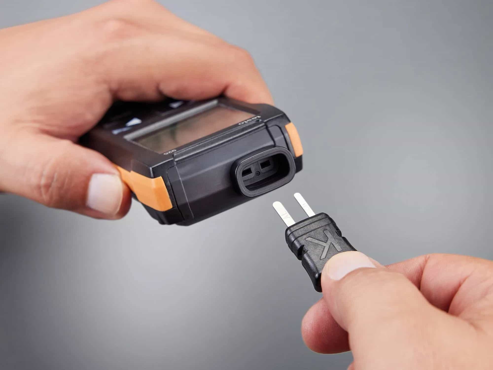 Dłonie podłączające wtyk sondy termoparowej typu K do gniazda termometru Testo 925 (miniatura)