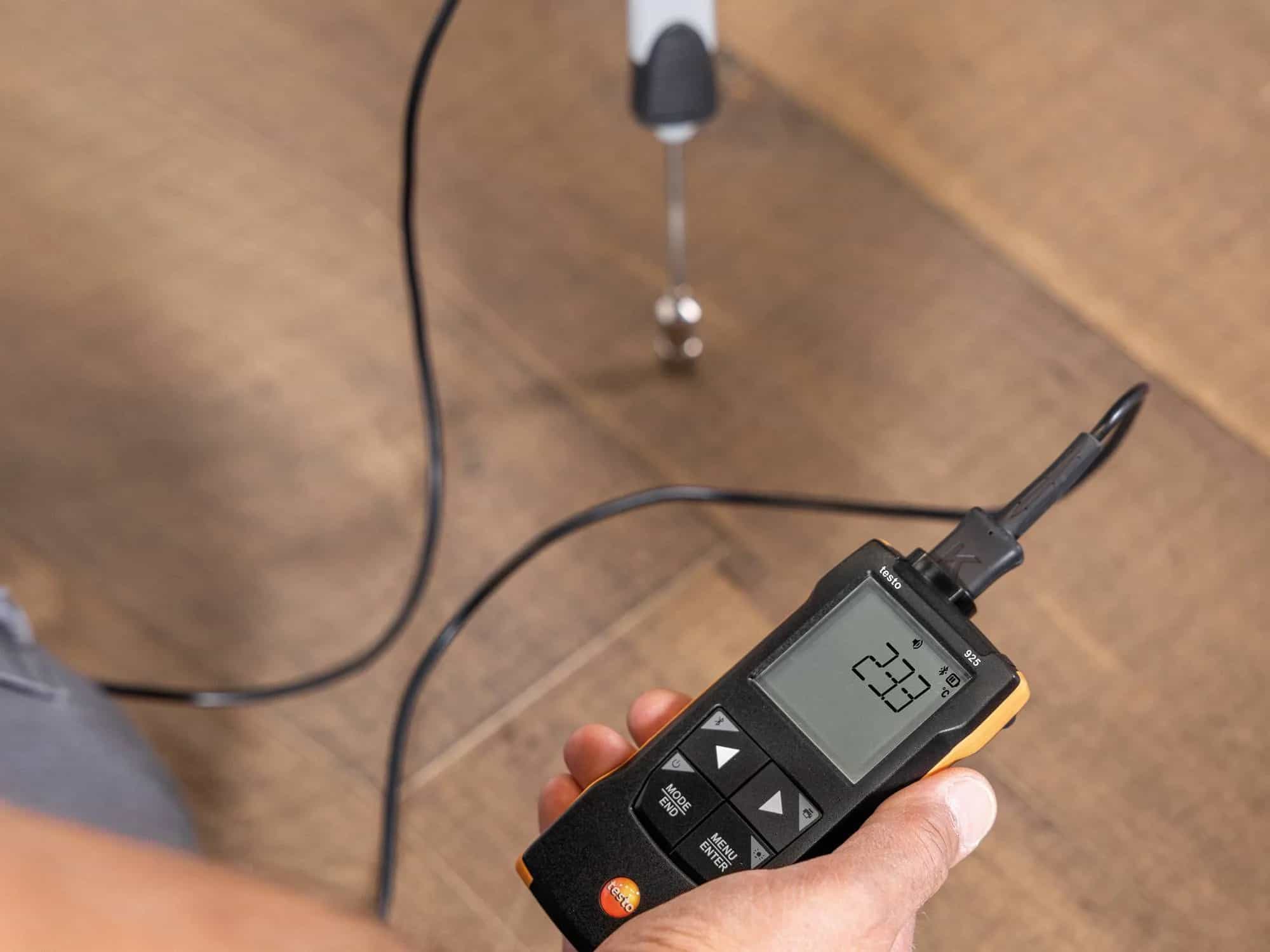 Technik trzymający termometr Testo 925 podczas pomiaru w terenie — widoczna sonda i wyświetlacz LCD (miniatura)