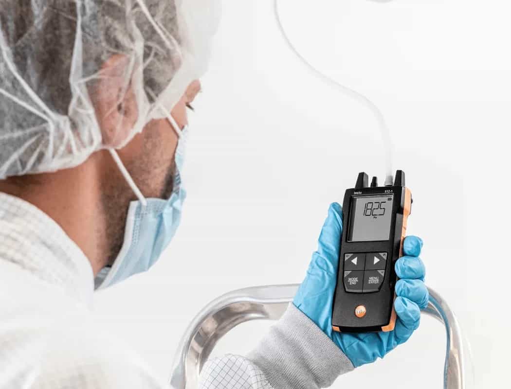 Technik mierzy różnicę ciśnień manometrem Testo 512-1 na kanale wentylacyjnym instalacji HVAC (miniatura)