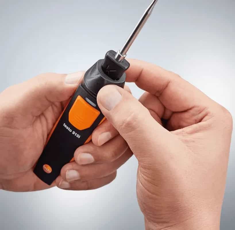 Dłonie trzymające termometr Testo 915i z sondą — praca z bezprzewodowym termometrem Bluetooth (miniatura)