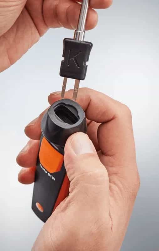 Dłonie wpinające sondę do rękojeści termometru Testo 915i — innowacyjny mechanizm blokujący (miniatura)