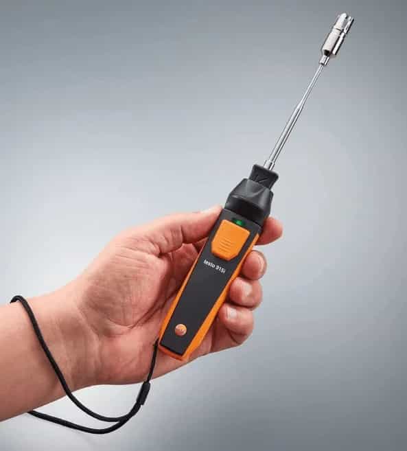 Technik trzymający termometr Testo 915i podczas pomiaru z połączeniem Bluetooth do aplikacji (miniatura)