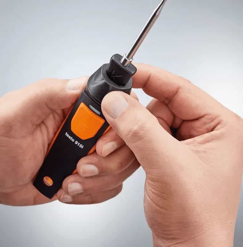 Dłonie demonstrujące mechanizm blokujący sondy w rękojeści termometru Testo 915i (miniatura)