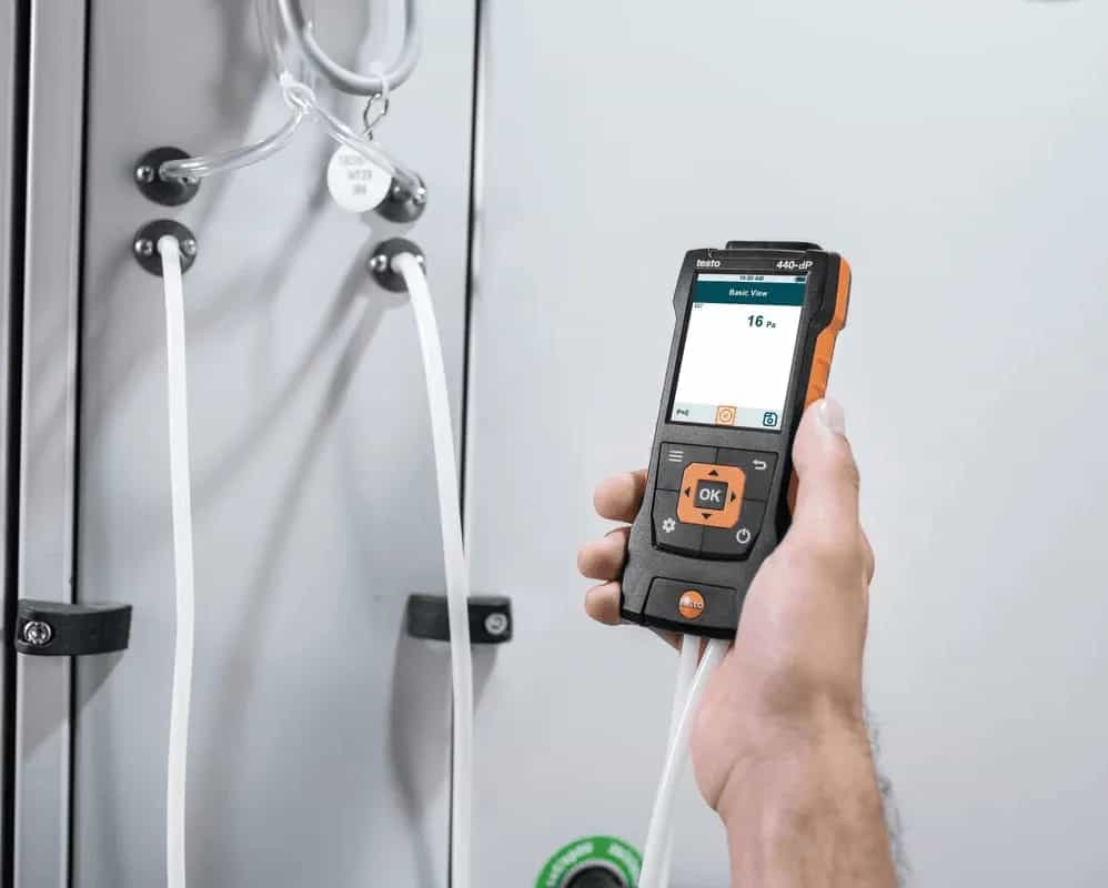 Pomiar różnicy ciśnień miernikiem Testo 440 dP podłączonym wężykami do stanowiska kontrolnego (miniatura)
