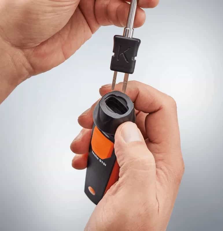 Dłonie wymieniające sondę w termometrze Testo 915i — mechanizm szybkiego blokowania (miniatura)