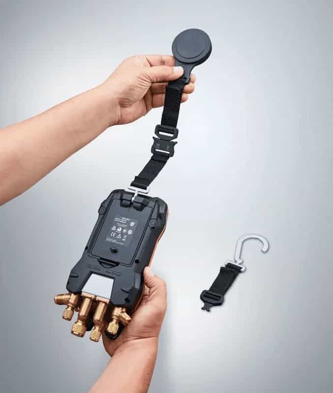 Elektroniczna oprawa zaworowa Testo zawieszona na pasku magnetycznym przy rzeczywistej instalacji chłodniczej w serwisie (miniatura)