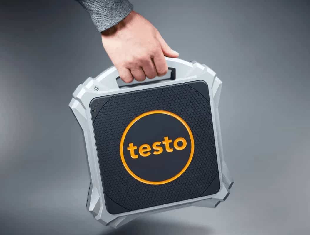 Technik trzymający wagę Testo 560i za uchwyt podczas pracy w terenie (miniatura)