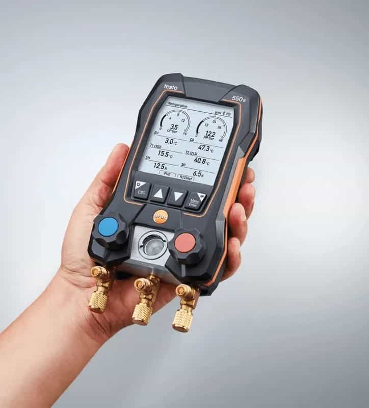 Elektroniczna oprawa zaworowa Testo 550s Smart trzymana w dłoni podczas pomiaru w terenie (miniatura)