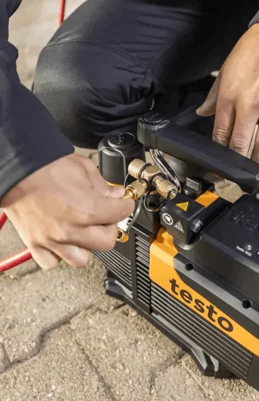 Technik podłączający węże serwisowe do pompy próżniowej Testo 565i na zleceniu serwisowym (miniatura)