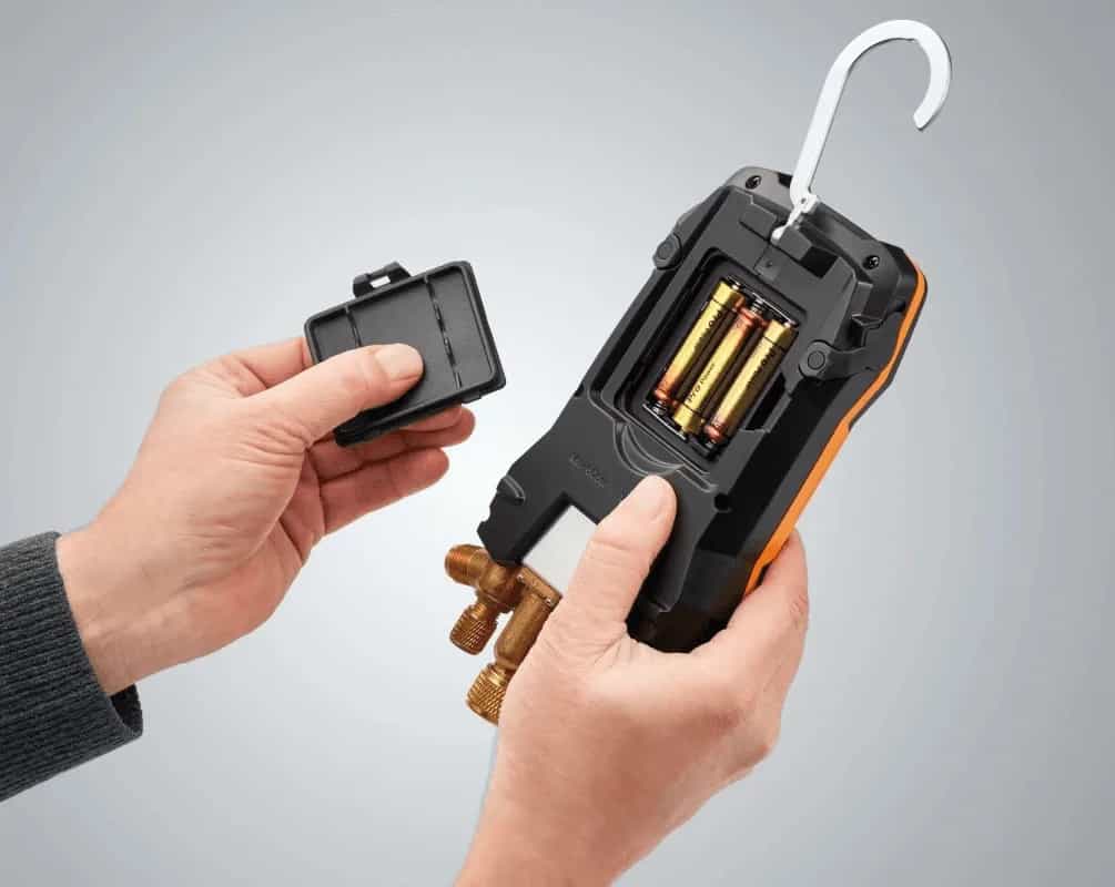 Dłonie wkładające pakiet baterii do oprawy zaworowej Testo 570s (miniatura)
