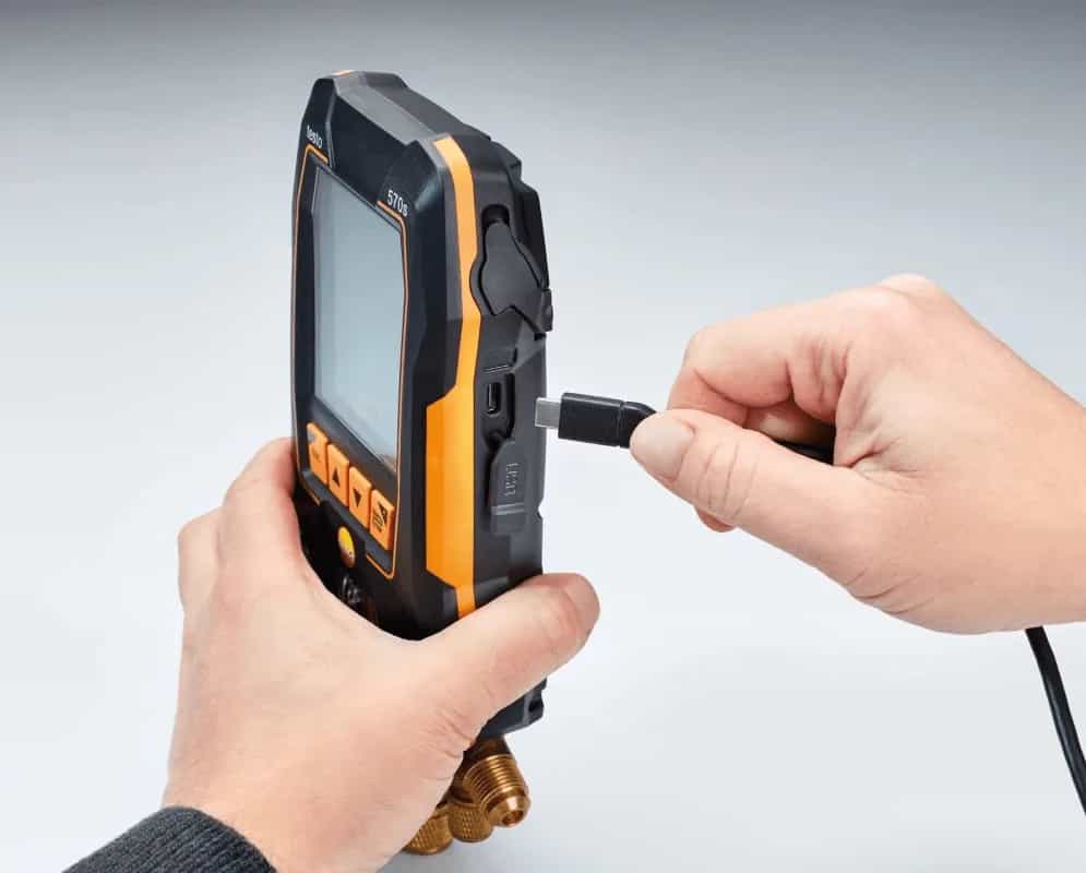 Serwisant obsługujący elektroniczną oprawę zaworową Testo 570s — podpinanie przewodu podczas pracy (miniatura)