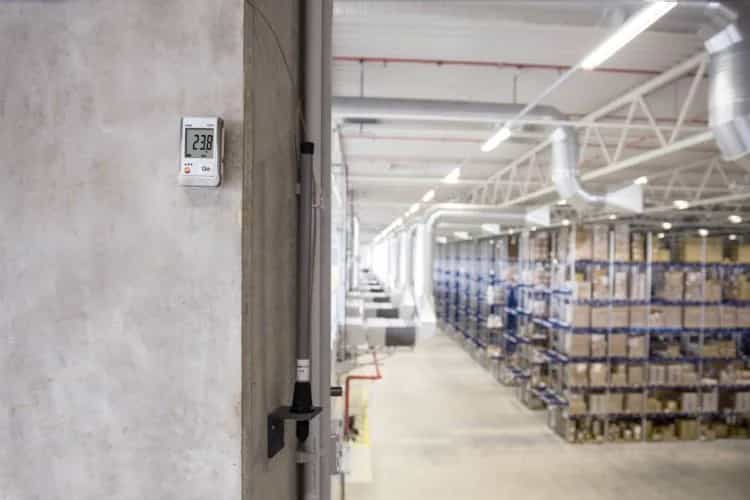 Rejestrator Testo 175 T1 zamontowany na słupie w hali logistycznej, w tle regały wysokiego składowania (miniatura)