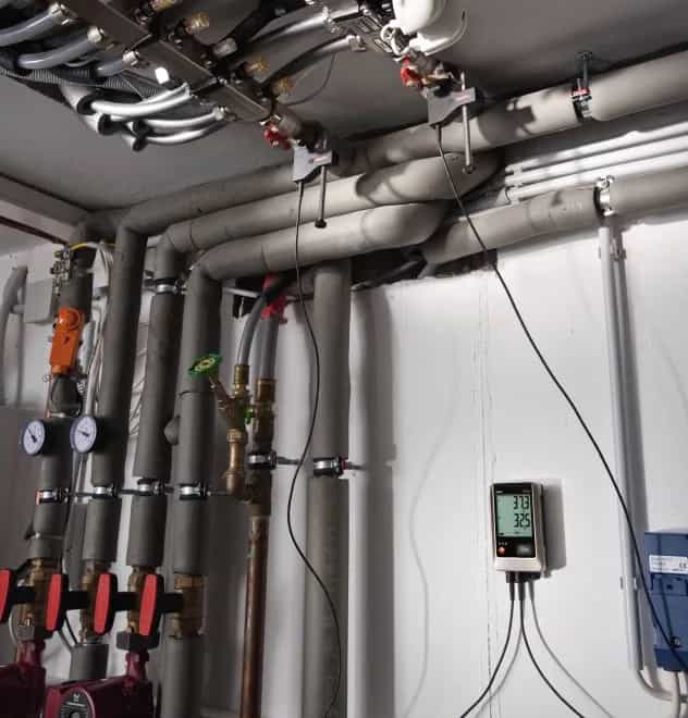 Rejestrator Testo 176 T4 zamontowany na ścianie kotłowni, monitorujący temperaturę zasilania i powrotu instalacji grzewczej (miniatura)