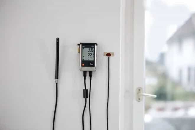 Rejestrator Testo 176 H1 zamontowany na ścianie z podłączoną zewnętrzną sondą temperatury i wilgotności (miniatura)