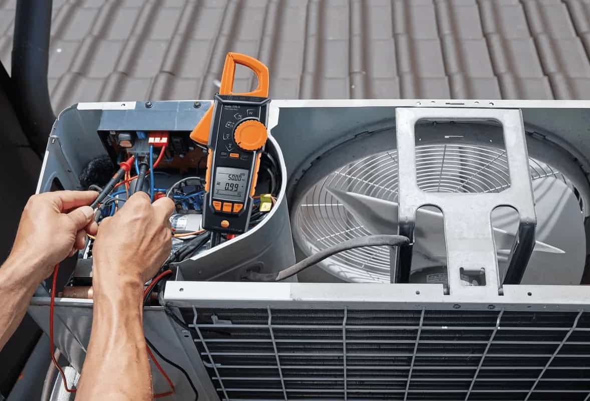 Elektryk mierzy amperomierzem cęgowym Testo 770-3 prąd w jednostce klimatyzacji na dachu (miniatura)