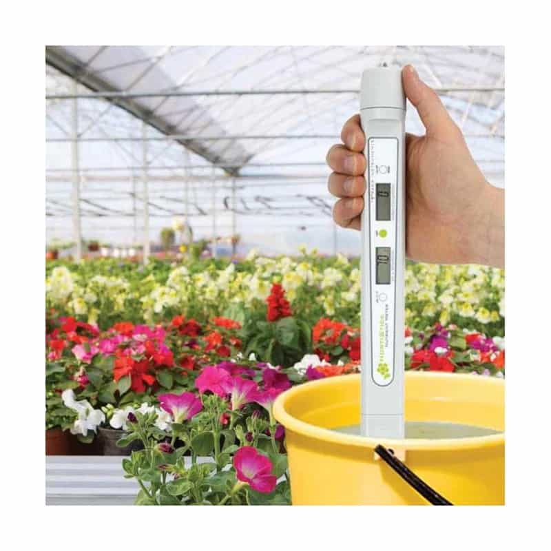 Tester ETI HortiStick podczas pomiaru pozywki w wiadrze w szklarni z kwiatami - zastosowanie w hydroponice (miniatura)