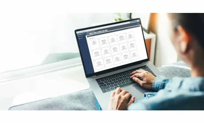 Kobieta pracująca z laptopem i platformą LI-COR Cloud IoT na świeżym powietrzu nad jeziorem (miniatura)