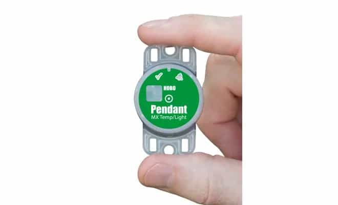 Rejestrator HOBO MX2202 trzymany w dłoni — kompaktowy logger temperatury i natężenia oświetlenia w skali ręki (miniatura)