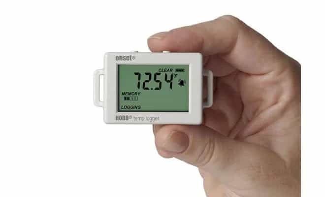Dłoń trzymająca rejestrator temperatury HOBO UX100-001 z aktywnym wyświetlaczem LCD (miniatura)