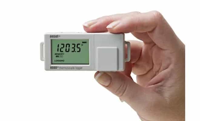 Dłoń trzymająca rejestrator temperatury HOBO UX100-014M — widok skali i wyświetlacza LCD (miniatura)