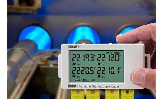 Rejestrator HOBO UX120-014M trzymany w dłoni z czterema termoparami podczas pomiaru temperatury palników gazowych (miniatura)