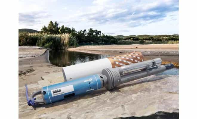 Rejestrator HOBO MX801 z adapterem i nasuniętą miedzianą osłoną antyporostową w terenowej instalacji nad brzegiem zbiornika wodnego (miniatura)