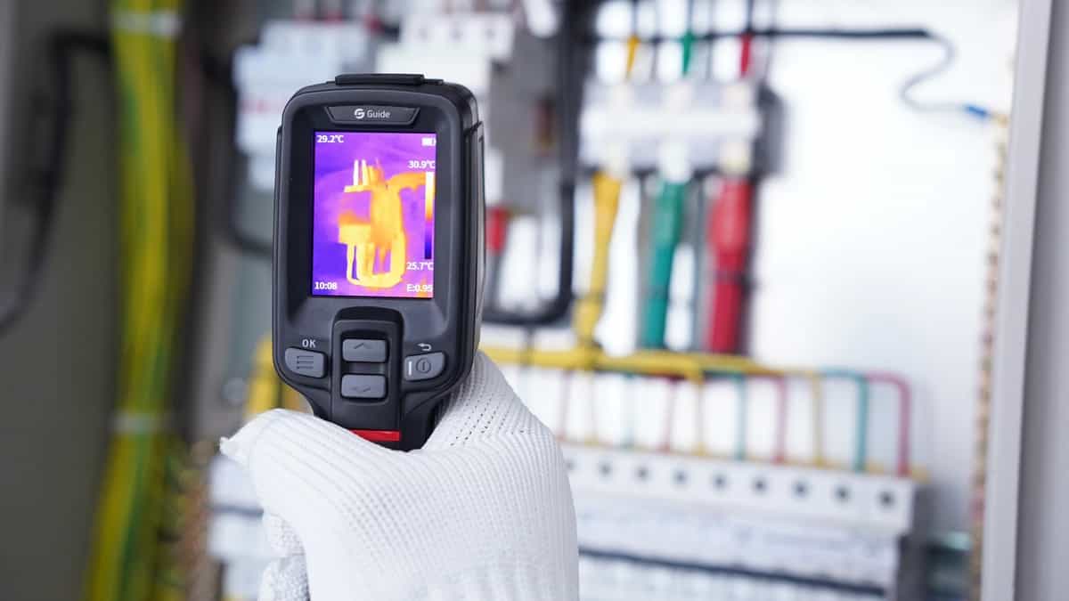 Kamera Guide serii EasIR w dłoni operatora z termogramem aparatów w rozdzielnicy (miniatura)
