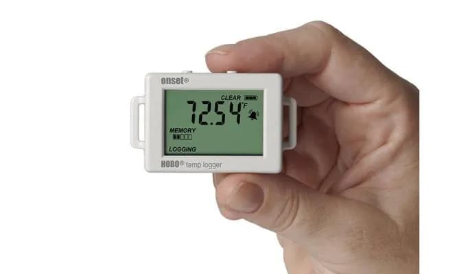 Dłoń trzymająca rejestrator temperatury HOBO UX100-001 z aktywnym wyświetlaczem LCD