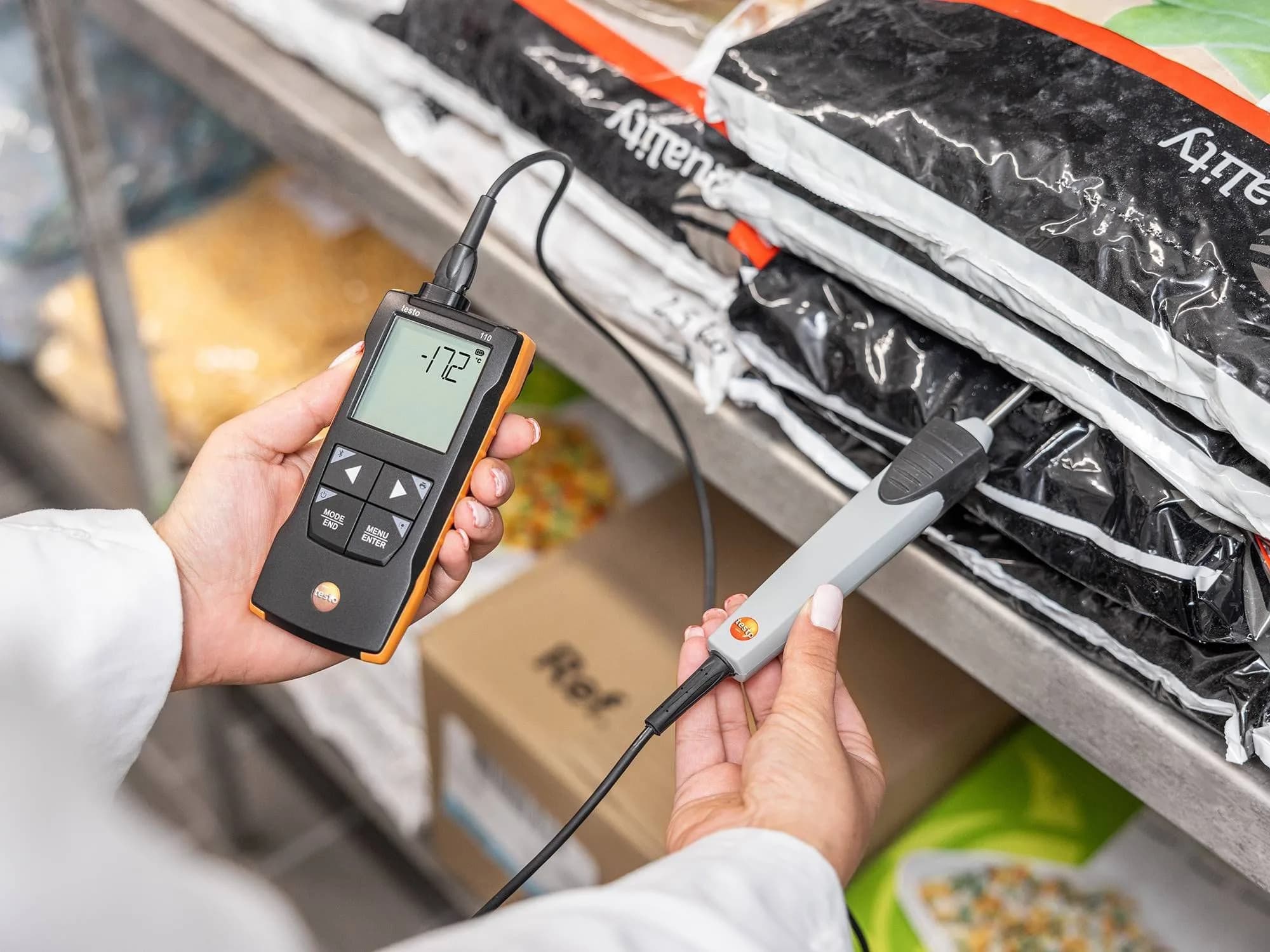 Testo 110 podczas pomiaru temperatury mrożonej żywności w magazynie chłodniczym — wyświetlacz pokazuje -17°C (miniatura)