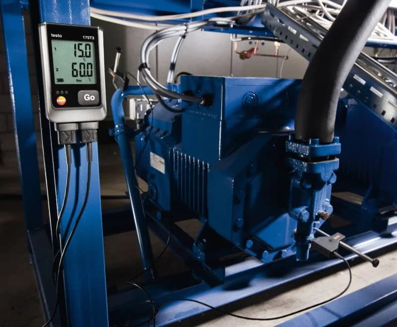 Rejestrator Testo 175 T3 zamontowany na ramie instalacji chłodniczej, z wyświetlaczem pokazującym dwie wartości temperatury (miniatura)
