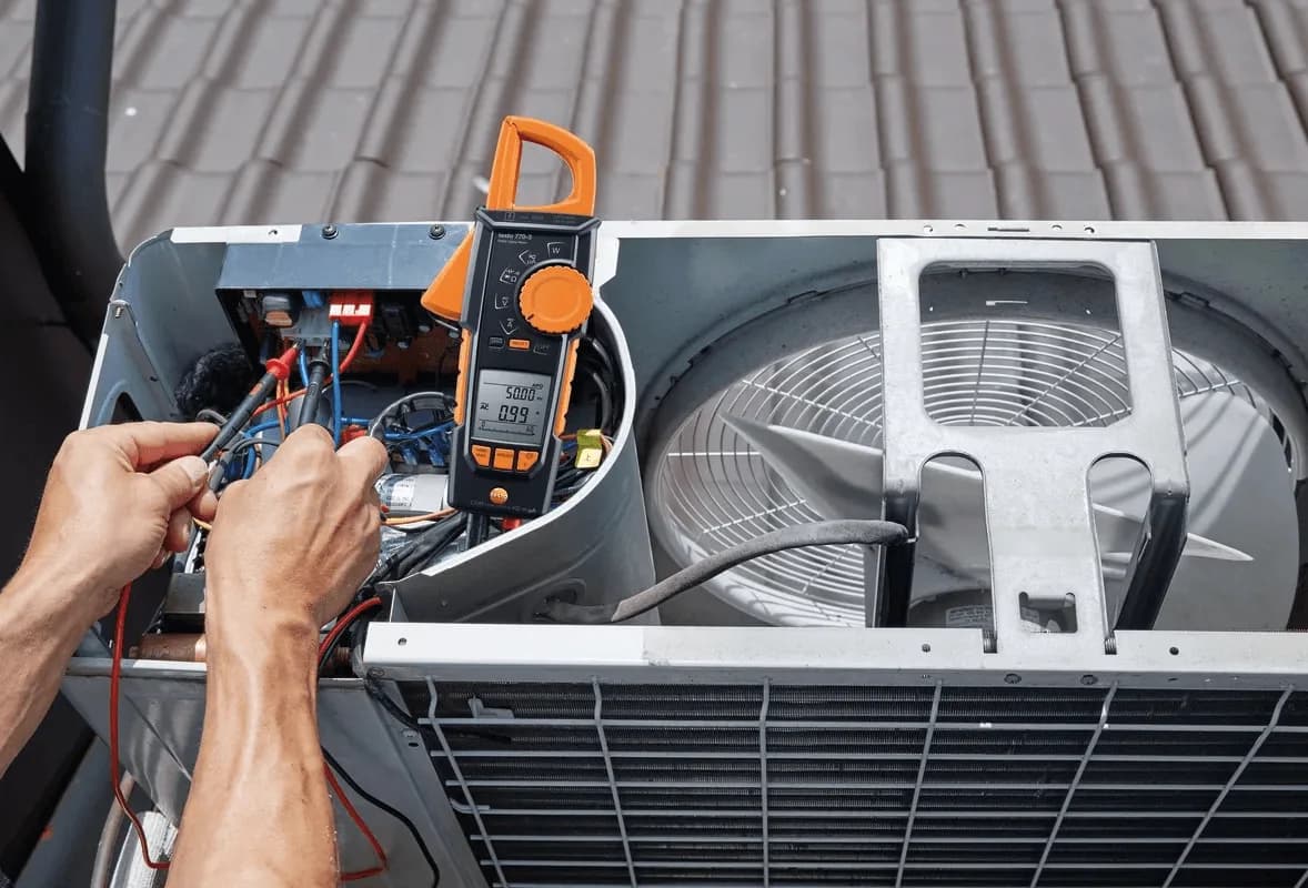 Elektryk mierzy amperomierzem cęgowym Testo 770-3 prąd w jednostce klimatyzacji na dachu (miniatura)