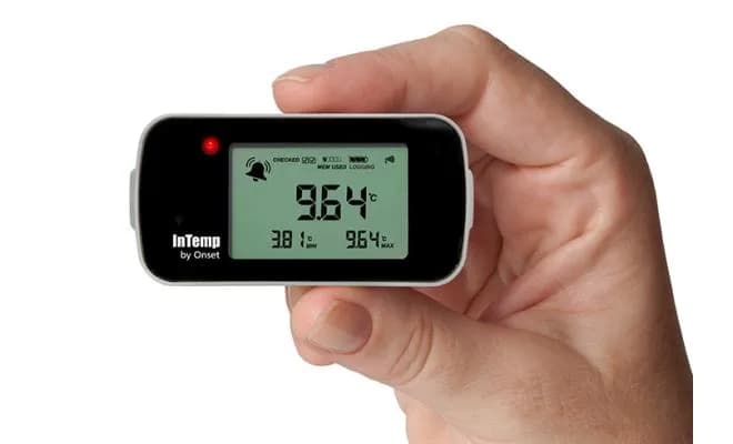 Dłoń trzymająca rejestrator Onset InTemp CX403 podczas bezprzewodowego odczytu Bluetooth (miniatura)