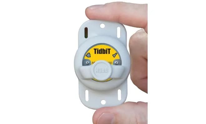 Rejestrator HOBO TidbiT MX2203 trzymany w dłoni podczas odczytu danych przez Bluetooth (miniatura)