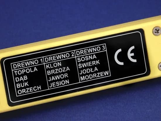 Wilgotnościomierz HYGROPEN leżący na desce drewnianej z elektrodami wbitymi w powierzchnię
