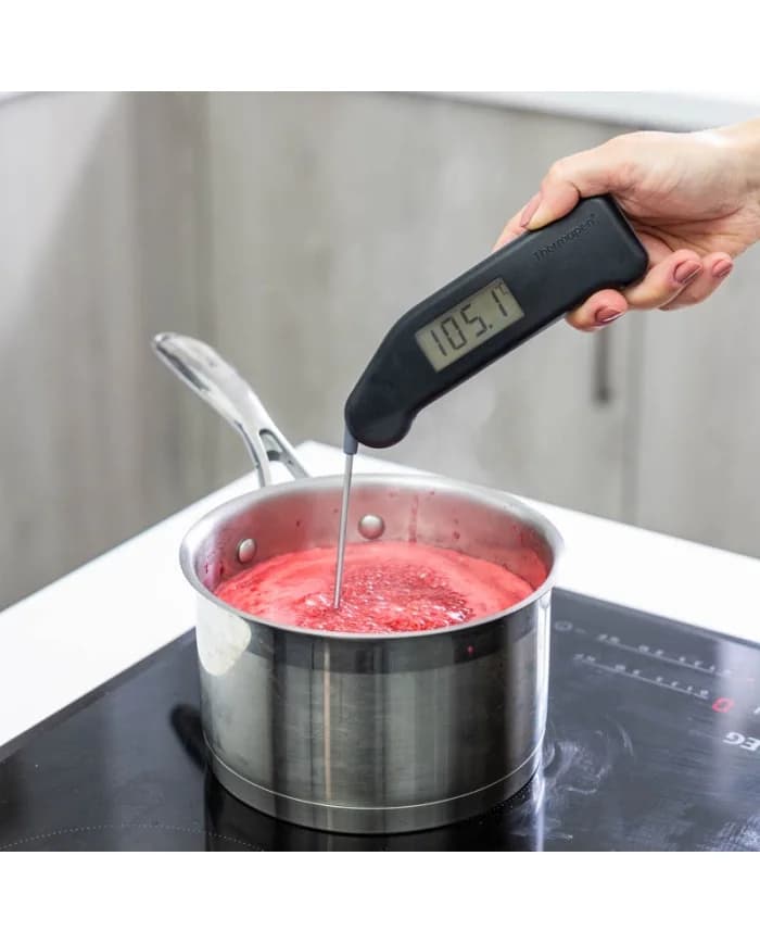 Składany termometr szpilkowy Thermapen Classic mierzy temperaturę sosu w rondlu na płycie indukcyjnej